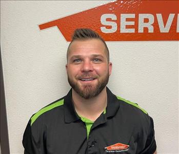 Male employee standing in front of Servpro sign
