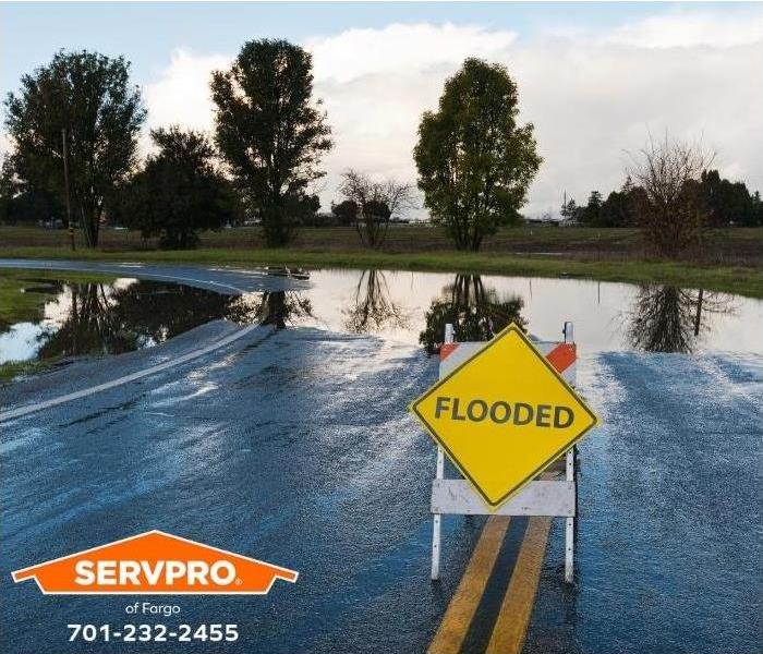 A sign warns of a flooded road.